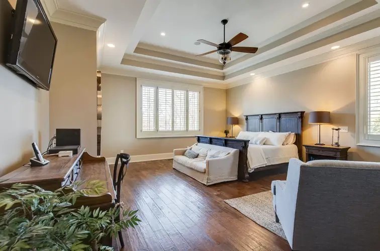 Theo Von house Nashville master bedroom with coffered ceiling plantation shutters and sitting area