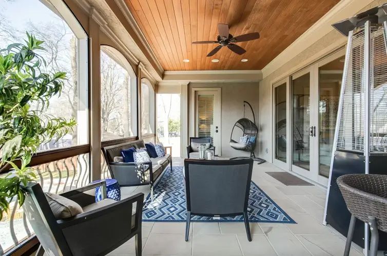 Theo Von house Nashville screened porch with wooden plank ceiling arched windows and hanging chair