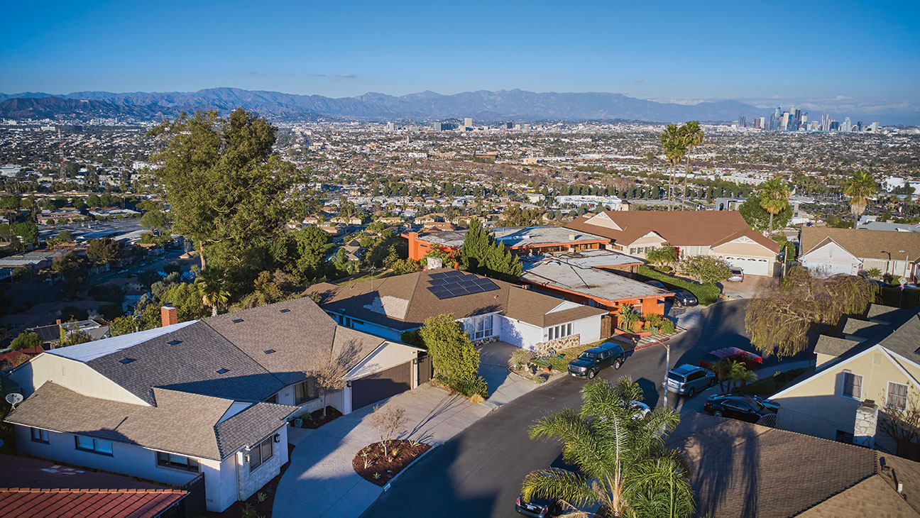 Aerial view of mid-century residential homes in the Baldwin Hills Crenshaw neighborhood of South Los Angeles with Santa Monica Mountains