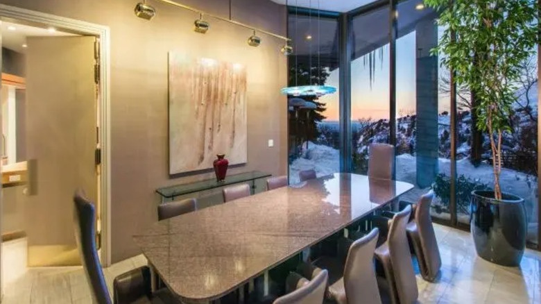 Formal dining room with marble table and glass walls overlooking the canyon