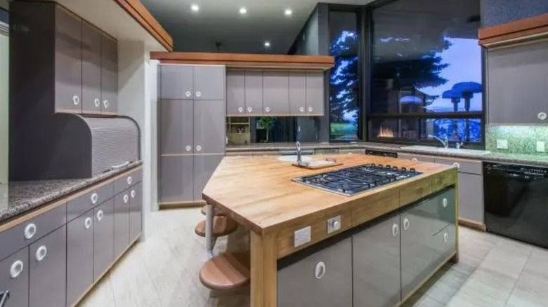 Gourmet chef's kitchen with island and wood cabinetry in Post Malone's Utah mansion