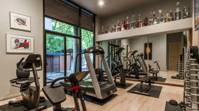 Home gym with trophies and mirrors showcasing fitness amenities and personal achievements