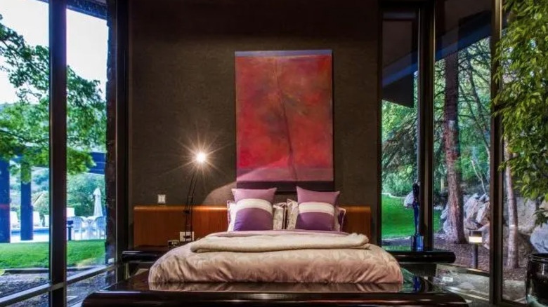 Interior room with floor-to-ceiling glass walls showcasing mountain views and contemporary art