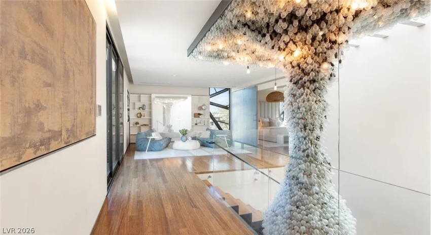 Jo Koy house interior: modern open floor plan Las Vegas mansion living room with lightbulb chandelier.