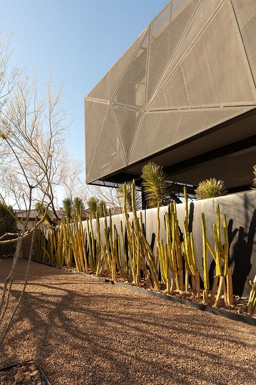 Jo Koy's Las Vegas mansion exterior with metal mesh facade, modern desert architecture, and desert landscaping in The Ridges.