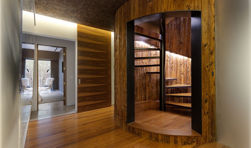 Jo Koy's Las Vegas mansion interior: modern design with spiral staircase in tree trunk-style wooden structure.
