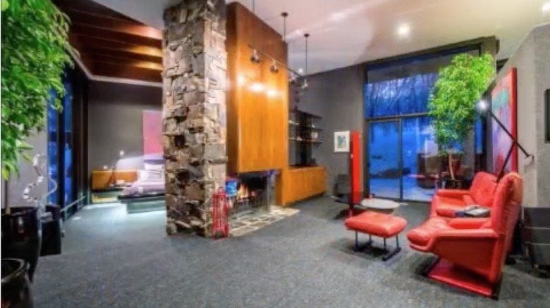 Living room with stone fireplace and red seating area, part of the integrated entertainment spaces