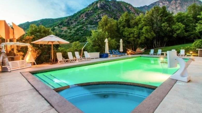 Rectangular outdoor pool with adjacent jacuzzi against the mountain backdrop