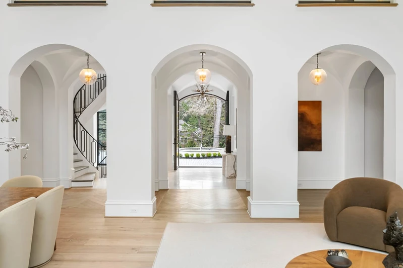 Mediterranean-inspired arches and iron-framed windows complement the contemporary design.