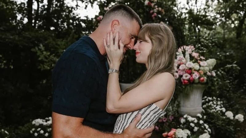 A couple shares an intimate moment in a lush flower-filled garden setting at the Leawood estate