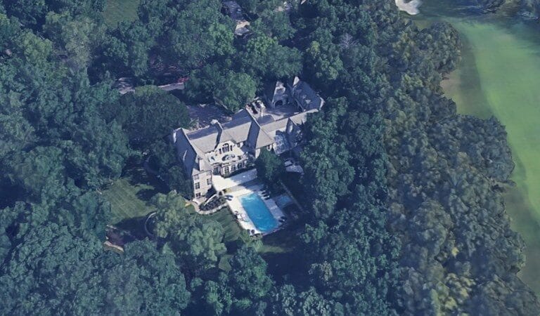 Aerial view of Travis Kelce's large Leawood mansion surrounded by dense trees with a swimming pool