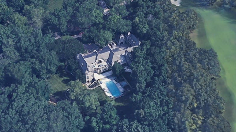 Aerial view of Travis Kelce's large Leawood mansion surrounded by dense trees with a swimming pool