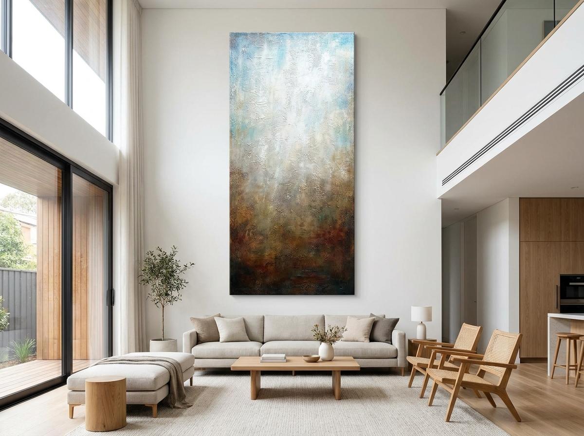 A tall vertical canvas anchors the seating area and draws the eye upward, making a standard ceiling feel noticeably taller