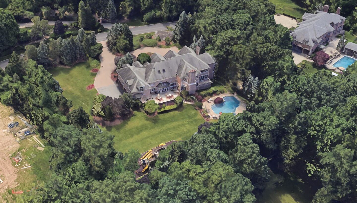 Aerial side view of Chris Rock's Alpine estate showing the residence, pool and tree-lined boundaries