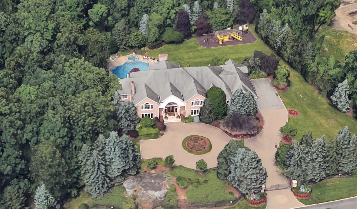 Oblique aerial view of Chris Rock's Alpine mansion showing the arched entry, complex roof and landscaped motor court
