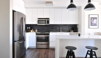 A bright luxury kitchen with island seating and carefully placed built-in appliances