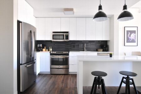 A bright luxury kitchen with island seating and carefully placed built-in appliances